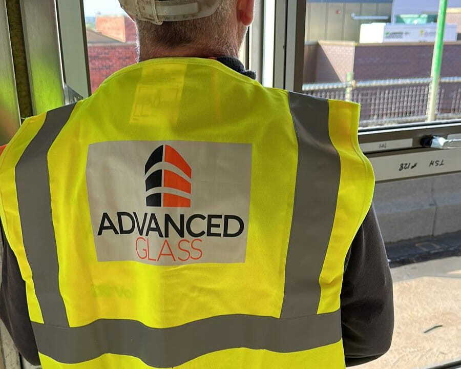 A worker inspecting fitted glass in a high-rise building, who are glazing sub-contractors part of the Advanced Glass team.. 